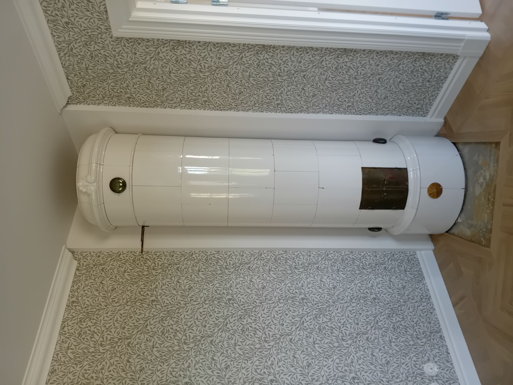 Vit kakelugn efter renovering utförd av mureri i Linköping